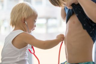 Der kleine Bruder hört seinem großen bruder an der brust ab